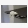 Cream 3D printed sleepy cat shelf-edge figure on a laptop edge